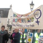 Women holding banner